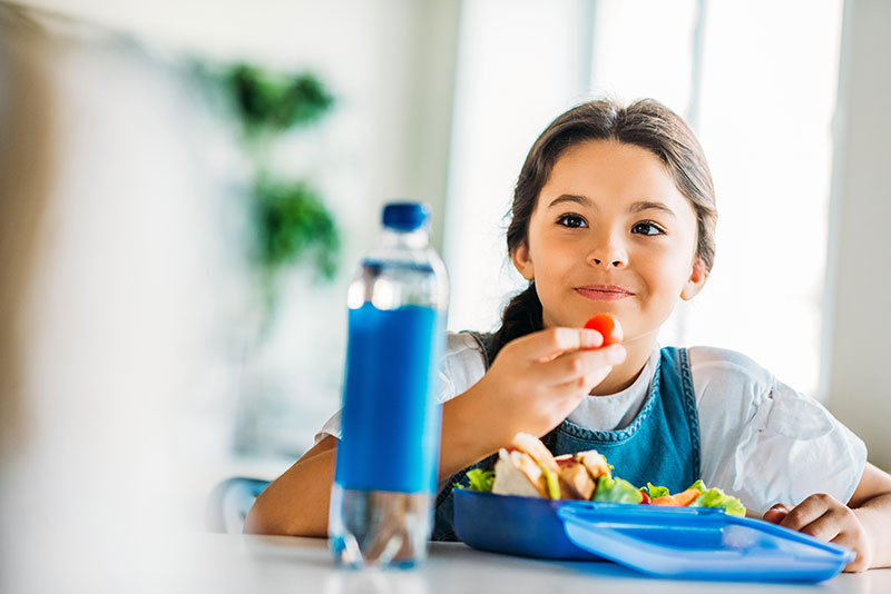Child eating healthy food at table